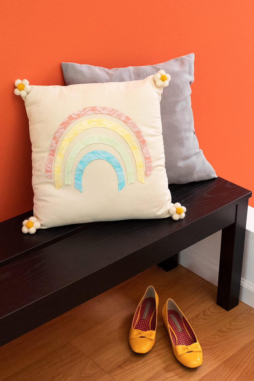 Rainbow pillow styled on a bench