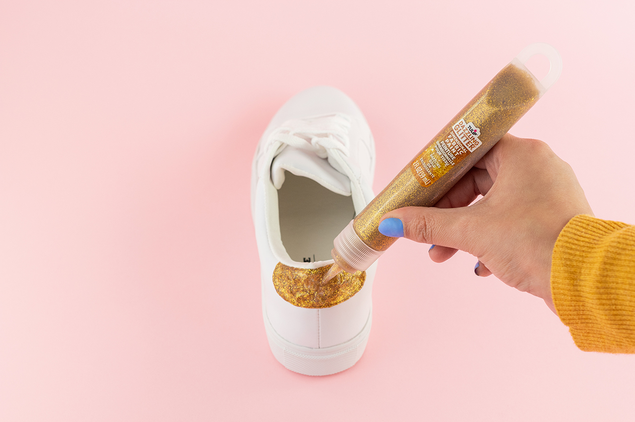 Adding gold glitter to shoes.